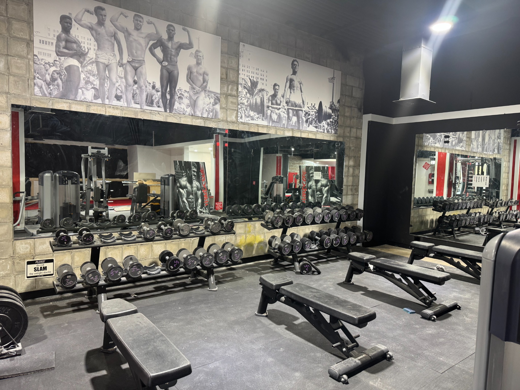 The dumbbell rack, benches, and mirrors at the new Suncoast Fitness